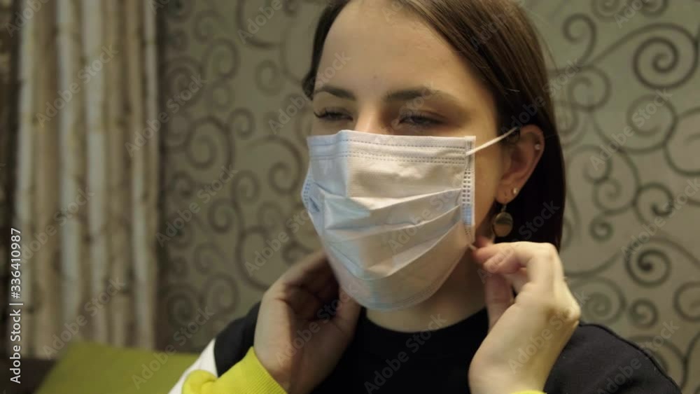 Young woman takes off medical mask. Female breathes deeply and smiling looking at camera. Isolated on white background. Health care and medical concept. Close up portrait . 4k Young woman takes off medical mask. Female breathes deeply and smiling looking at camera. Isolated on white background. Health care and medical concept. Close up portrait . 4k
