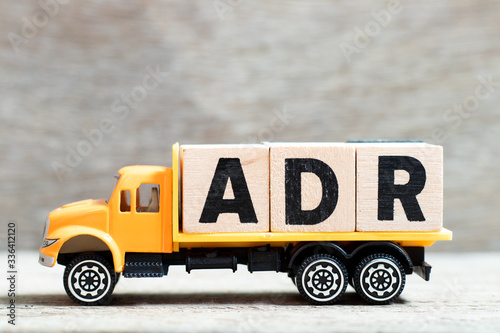 Truck hold letter block in word ADR (Abbreviation of Adverse drug reaction) on wood background photo