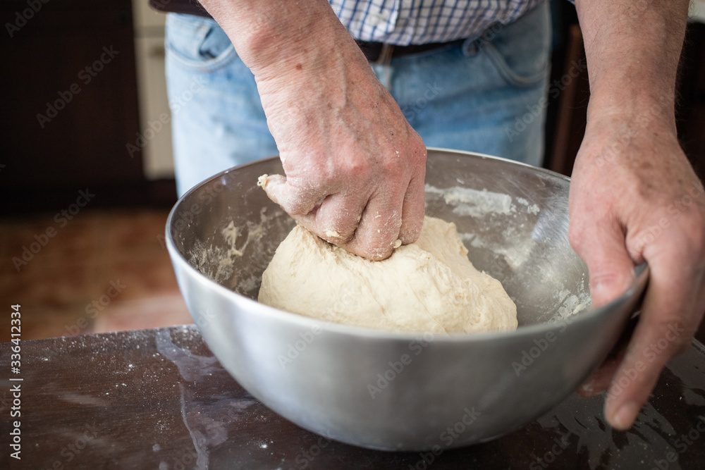 Fototapeta premium male hands making bread in kitchen at home