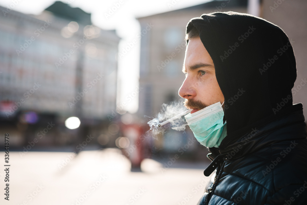 Foto de Smoking. Closeup man with mask during COVID19 pandemic smoking a cigarette at the