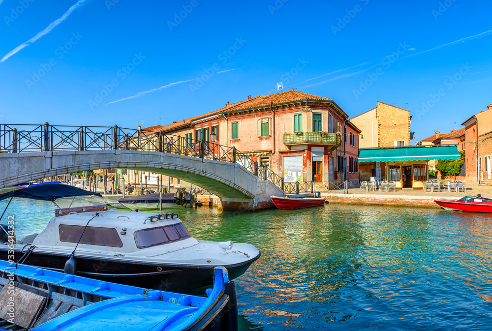 Canal with old buildings and boats in Murano island, Venice, Italy. Architecture and landmarks of Venice. Venice postcard