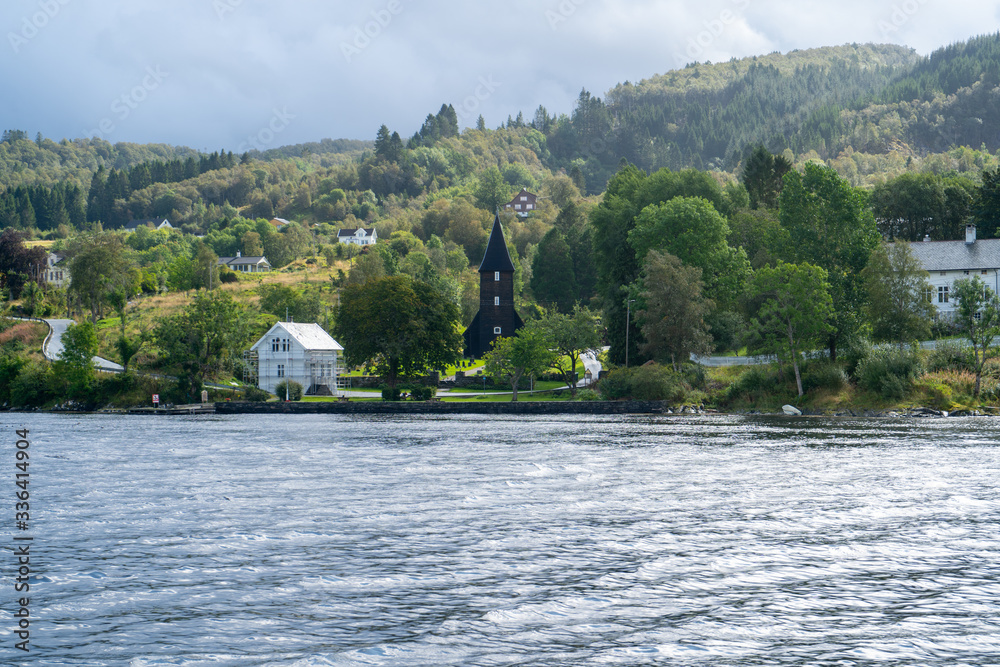 August 2019: Unusual black church on the shore of the fjord near Bergen city, Norway. August 2019: Unusual black church on the shore of the fjord near Bergen city, Norway.