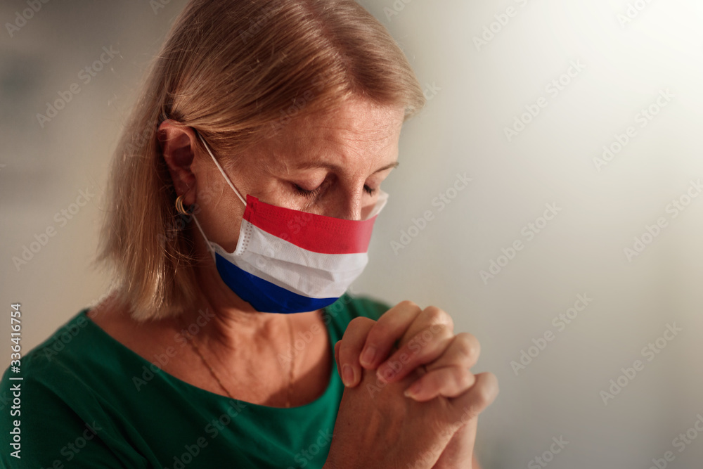 Woman in face mask praying for the Netherlands Woman in face mask praying for the Netherlands