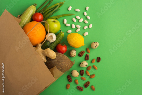 Paper bag of vegetables and fruits on the green background. Bag food concept. Top view.Copy space.