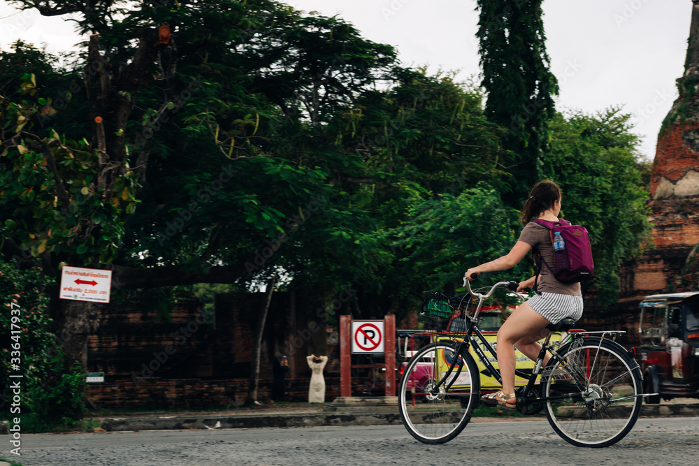 Woman riding a bicycle  near Ayutthaya historical park in Thailand,