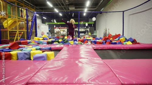 Children jumping on trampolines indoors, having fun on trampoline at local amusement park.
