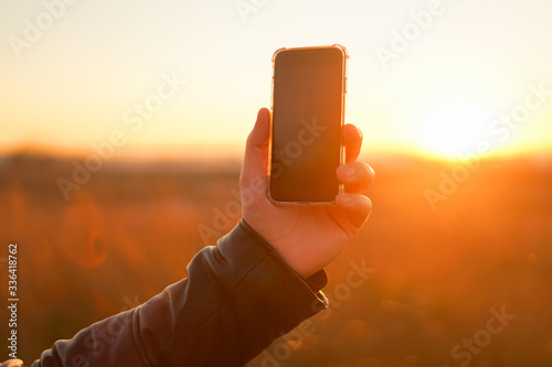 Hand in the sun with a phone close-up