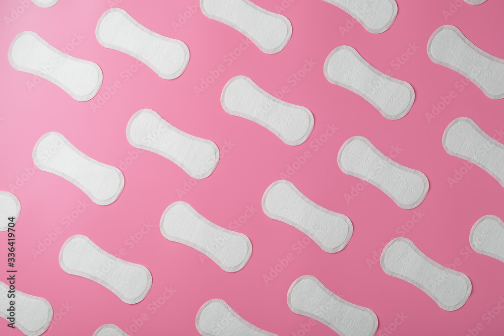 Sanitary pad on a pink background in the form of a diagonal pattern. Textured background over the entire screen. Sanitary pad on a pink background in the form of a diagonal pattern. Textured background over the entire screen.