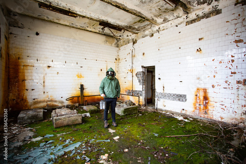 Dramatic portrait of a man wearing a gas mask in a ruined building. © erika8213