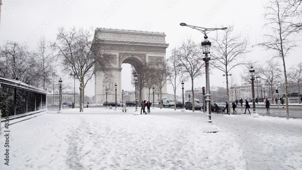 Champs-Elysees Avenue in Paris France, in winter with snow, with traffic and the Arc de Triomphe in the background, on a snowy day