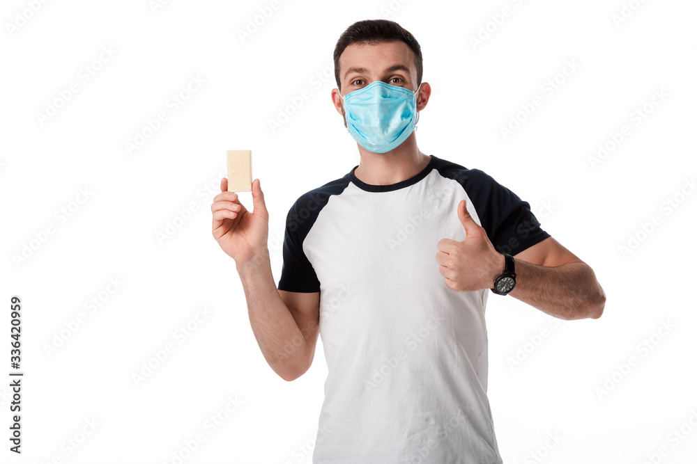 man in medical mask showing thumb up and holding soap bar isolated on white man in medical mask showing thumb up and holding soap bar isolated on white