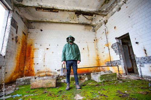 Dramatic portrait of a man wearing a gas mask in a ruined building. © erika8213