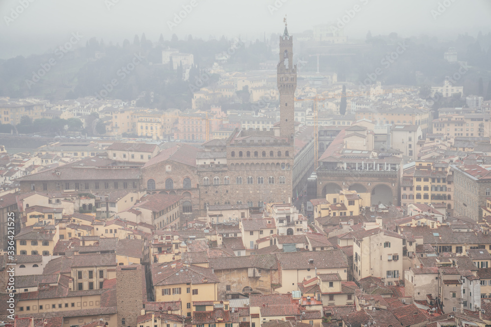 view of Palazzo Vecchio and Loggia dei Lanzi from the dome of the Duomo in Florence on a foggy day