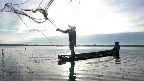 Silhouette of Asian fisherman with fishing net casting fish by throwing fishing net into the lake in morning sunshine.Fish is nature food from river or lake at rural in developing country
poor living.