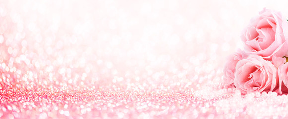 Pink roses bouquet and pearls on abstract blur pastel background. Wedding flowers and bright bokeh glitter backdrop.