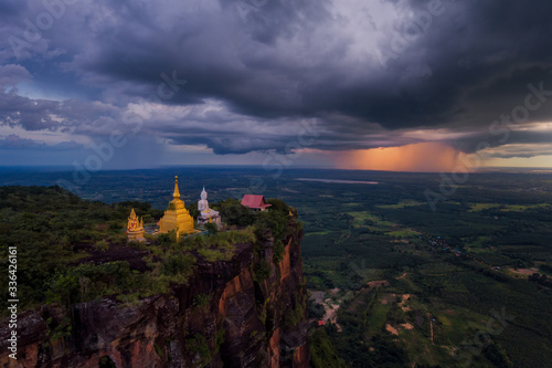 Buddha on the mountain of thunderstorm clouds Above the field of sunsets