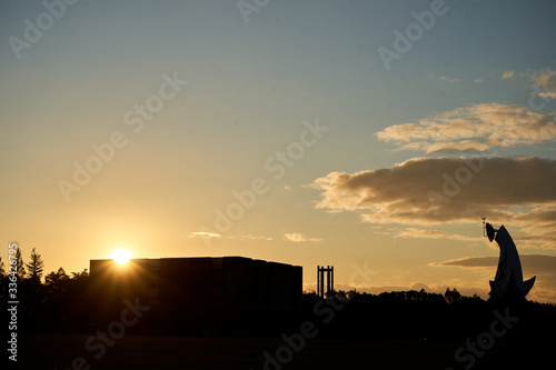 Silhouette of building and huge sculpture during the sunset