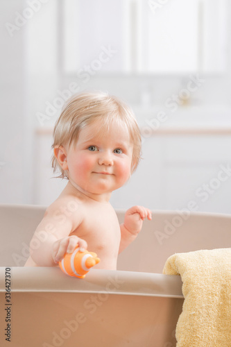A Happy toddler bathing in bathtub.