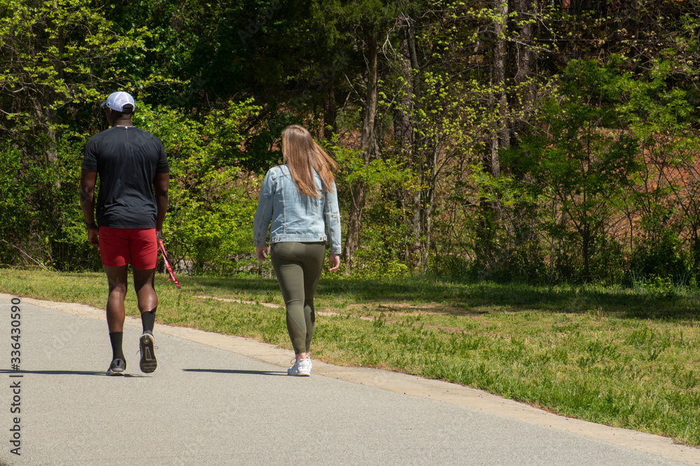 A young interracial couple go for a walk along a hiking trail A young interracial couple go for a walk along a hiking trail