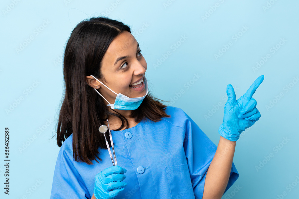 Young brunette mixed race dentist woman holding tools over isolated background pointing with the index finger a great idea Young brunette mixed race dentist woman holding tools over isolated background pointing with the index finger a great idea