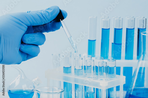 scientific laboratory equipment. hands of a scientific researcher in blue gloves