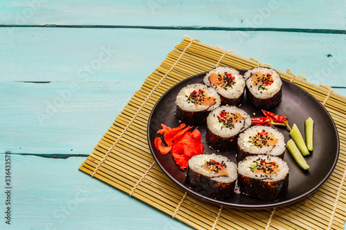 Korean roll Gimbap(kimbob). Steamed white rice (bap) and various other ingredients. Trendy turquoise background
