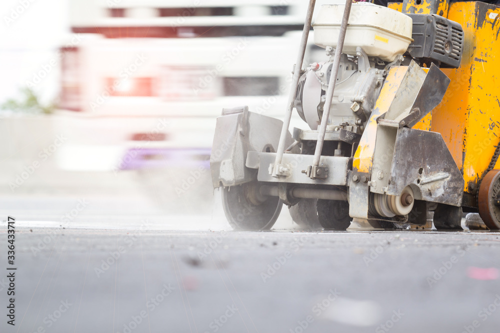 Concrete Road Cutters with worker when raining over the sand truck blurred background, constructor building concept Concrete Road Cutters with worker when raining over the sand truck blurred background, constructor building concept