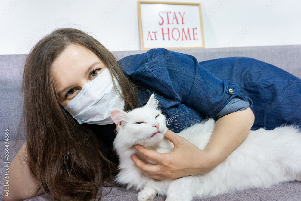 Young woman relaxing at home with pet cat. Cozy time at home. Self time and Coronavirus outbreak quarantin concept. Young woman relaxing at home with pet cat. Cozy time at home. Self time and Coronavirus outbreak quarantin concept.