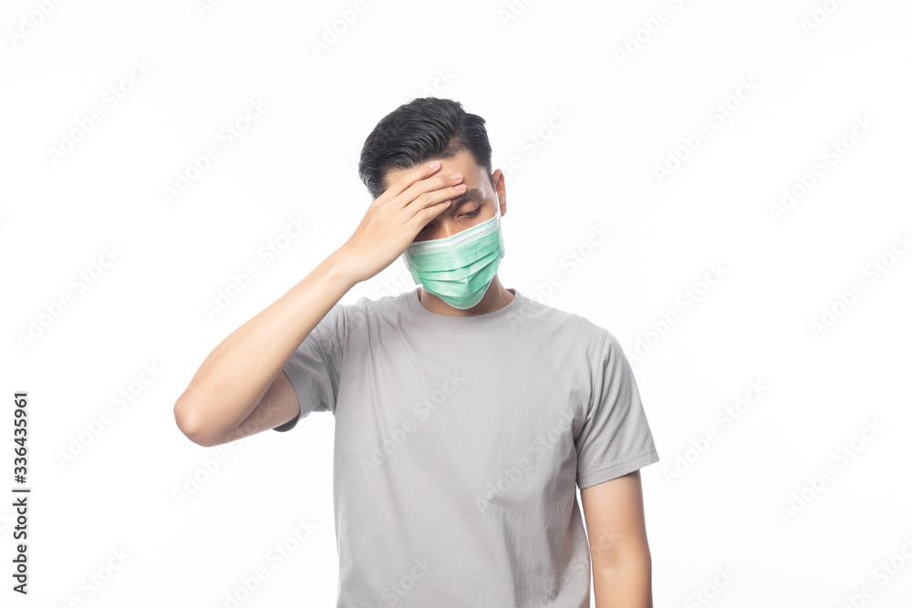 Young Asian Man in hygienic mask headache and having flu, 2019-nCoV or coronavirus. Airborne respiratory illness such as pm 2.5 fighting. Studio shot isolated on white background. Young Asian Man in hygienic mask headache and having flu, 2019-nCoV or coronavirus. Airborne respiratory illness such as pm 2.5 fighting. Studio shot isolated on white background.