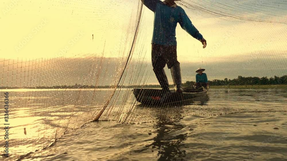 Silhouette of Asian fisherman with fishing net casting fish by throwing fishing net into the lake in morning sunshine.Fish is nature food from river or lake at rural in developing country
poor living.