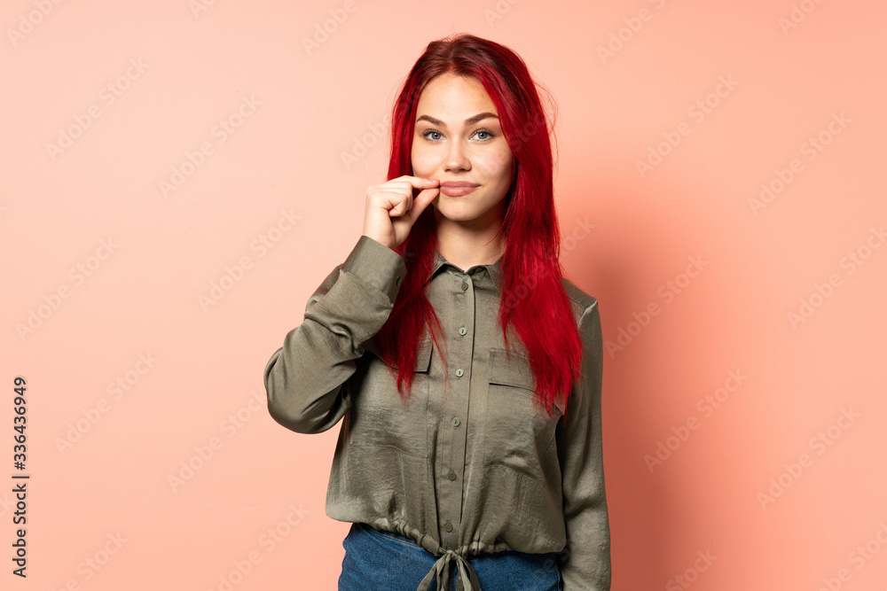 Teenager red hair girl isolated on pink background showing a sign of silence gesture Teenager red hair girl isolated on pink background showing a sign of silence gesture