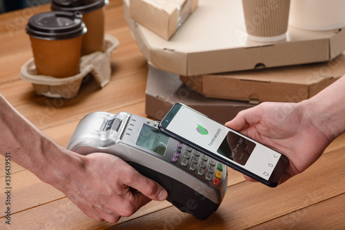 Man paying for pizza and coffee with his phone