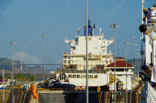 Cargo, container and tanker ships pass through Miraflores Locks in famous Panama Canal, masterpiece of human engineering near Panama City in Central America, with Centennial Bridge in background photo