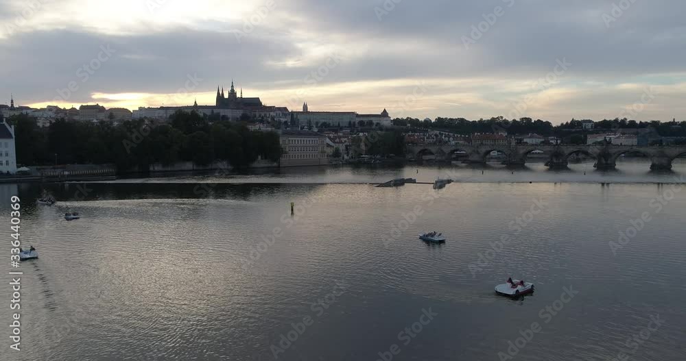 The Prague Castle and the Charles bridge during sunset, drone shot pullback with panning right The Prague Castle and the Charles bridge during sunset, drone shot pullback with panning right