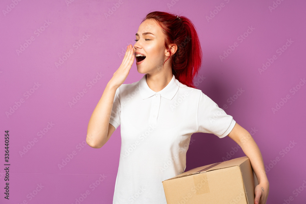 Teenager delivery girl isolated on purple background yawning and covering wide open mouth with hand Teenager delivery girl isolated on purple background yawning and covering wide open mouth with hand