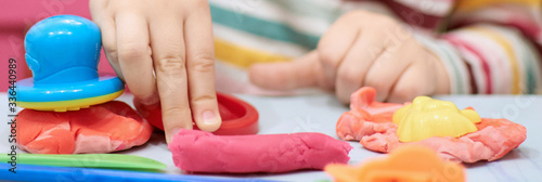 Child hands playing with colorful plasticine during quarantine Covid-19