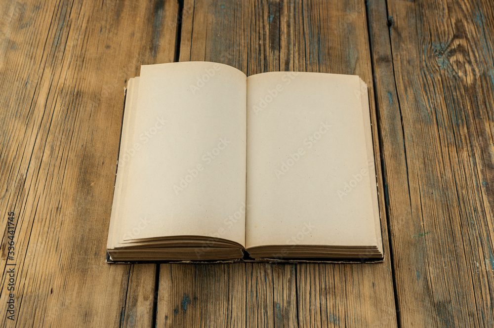 Fototapeta premium Vintage book, open, on old wooden table.