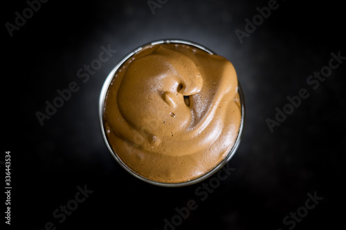 Iced Dalgona Coffee, a trendy korean style  cremy whipped coffee on fresh milk, on black background. Top view photo