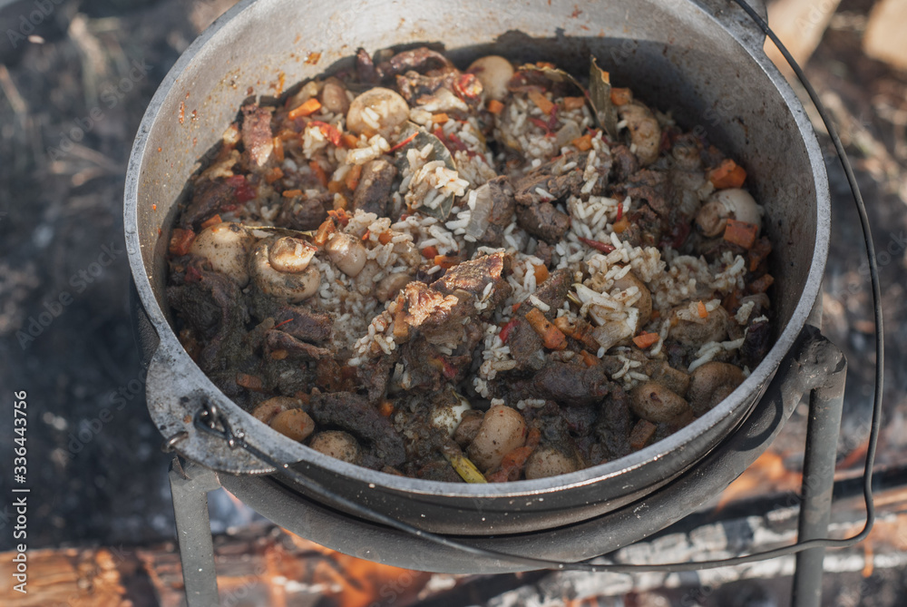 Pilaf with mushrooms in a cauldron cooked over a fire, Pilaf with mushrooms in a cauldron cooked over a fire,