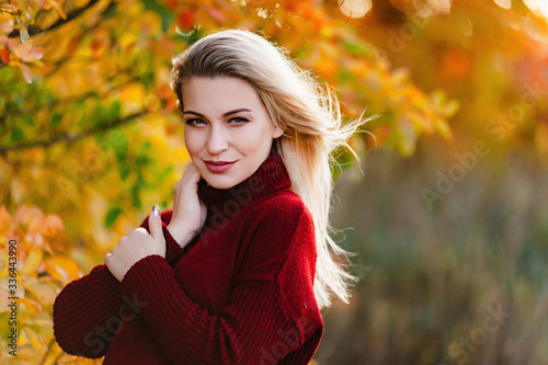 Beautiful pregnant girl blonde on nature in the yellow and red leaves of autumn