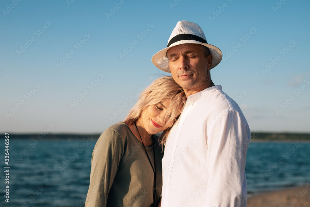 woman and man walk on the beach at sunset