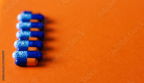 Fotografie Heap of colorfull pills, tablets, capsules on yellow orange background