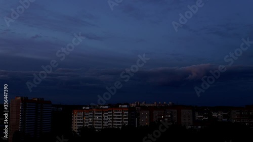 Timelapse footage: panorama over the city, at sunset clouds move in opposite directions