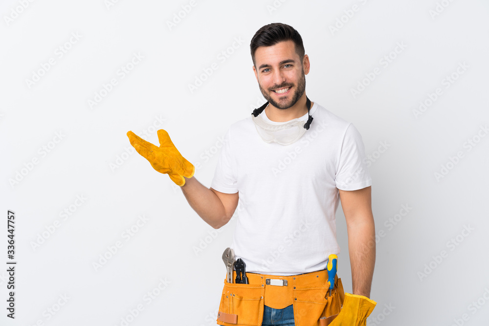 Craftsmen or electrician man over isolated white background holding copyspace imaginary on the palm - obrazy, fototapety, plakaty 