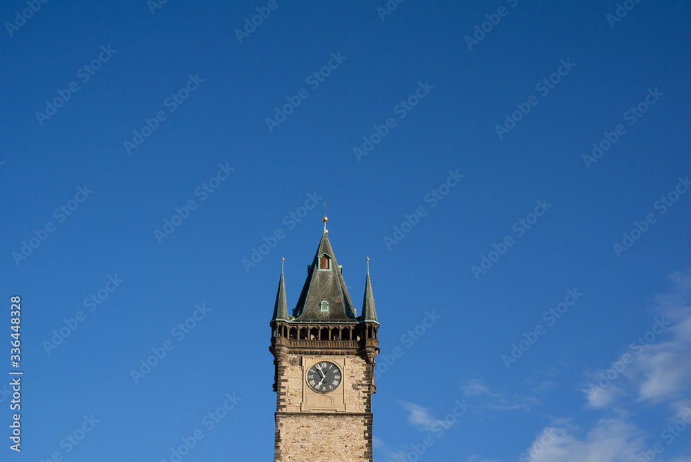 Old town Hall, Prague, Czech Republic / Czechia - top of the historical building with tower and spire. Architecture is made in gothic style. Clear blue sky as large copy space.