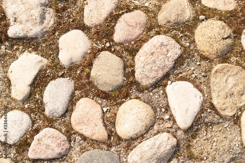 Cobbled surface with paving stones in different shades - top view.Natural stone pavement. Exterior floor covering. Cobbled surface with paving stones in different shades - top view.Natural stone pavement. Exterior floor covering.