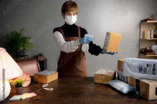 A person spraying disinfectant on parcels and boxs during coronavirus Covid-19 pandemic