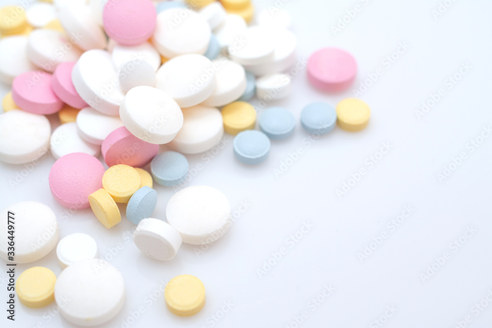 colored painkiller pills on a blue background and place for text