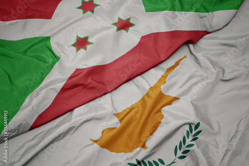 waving colorful flag of cyprus and national flag of burundi .