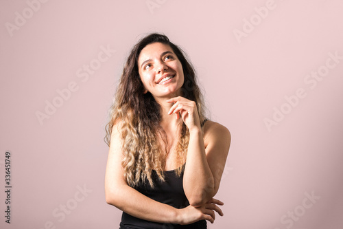 portrait of a young cheerful woman with freckles skin green eyes and curly hairs in black t-shirt smiling. natural beauty and body positive
